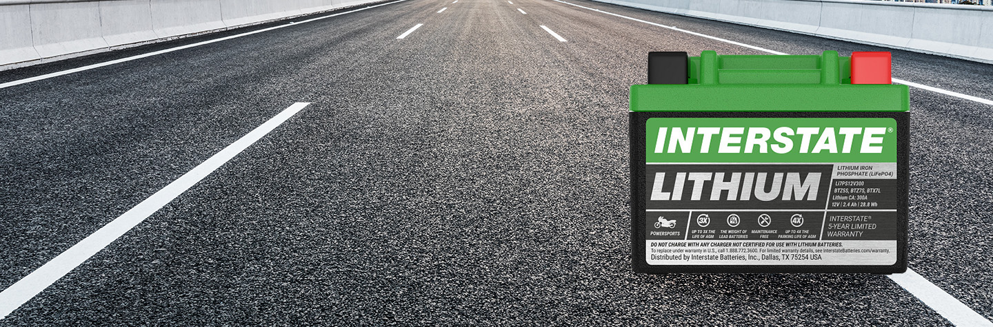 Interstate lithium powersports battery on open paved highway with lane markings stretching into the distance